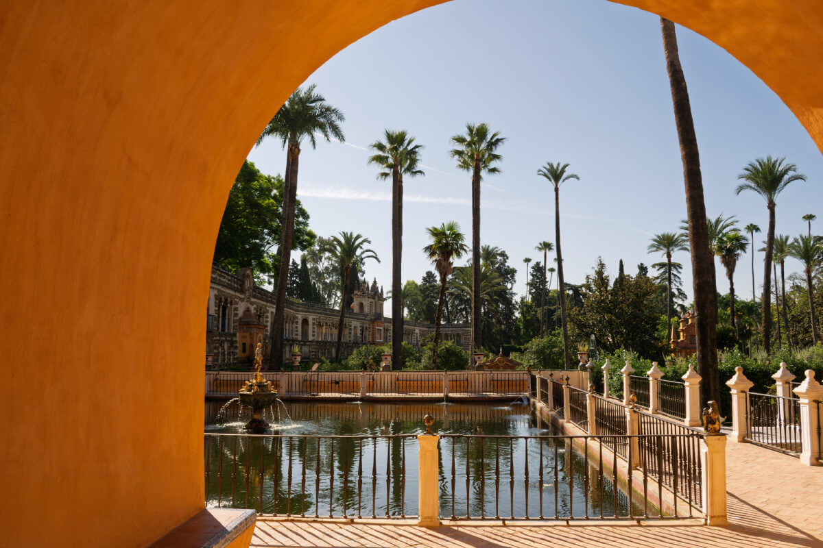 Estanque de Mercurio y Galería del Grutesco del Real Alcázar de Sevilla vistos bajo un arco